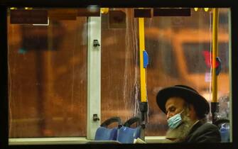 epa08674108 An Ultra-Orthodox Jew wearing a protective face mask uses the public transportation in Jerusalem, 16 September 2020. The Israeli cabinet approved a full three weeks lockdown during the Jewish holidays period beginning on 18 September aimed to prevent the spread of the coronavirus and COVID-19 disease outbreak.  EPA/ATEF SAFADI
