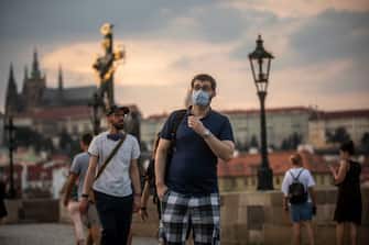 PRAGUE, CZECH REPUBLIC - SEPTEMBER 16: Tourists wearing face masks walk at sunset on medieval Charles Bridge on September 16, 2020, in Prague, Czech Republic. The Czech Republic records the highest increase of COVID-19 infected patients since the beginning of the pandemic of coronavirus spread, over 1000 daily. (Photo by Gabriel Kuchta/Getty Images)