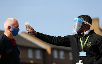 LONDON, ENGLAND - SEPTEMBER 19: A fan has his temperature checked by a steward wearing a face shield outside the stadium ahead of the Sky Bet League One match between Charlton Athletic and Doncaster Rovers at The Valley on September 19, 2020 in London, England. Charlton Athletic Football Club are allowing limited number of spectators (1000) to be in attendance as Covid-19 pandemic restrictions are eased. (Photo by James Chance/Getty Images)