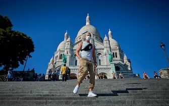 PARIS, FRANCE - SEPTEMBER 14: A tourist walk down the famous steps in front of SacrÃ© CÅ ur Basilica wearing a face mask since the city made the wearing of a mask compulsory after the recent surge of COVID-19 cases in the city on September 14, 2020 in Paris, France. On Saturday, the number of new daily cases exceeded 10,000, with infection rates rising among all age groups. (Photo by Kiran Ridley/Getty Images)