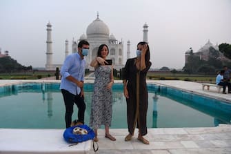 Tourists take pictures as the visit the Taj Mahal in Agra on September 21, 2020. - The Taj Mahal reopened to visitors on September 21 in a symbolic business-as-usual gesture even as India looks set to overtake the US as the global leader in coronavirus infections. (Photo by Sajjad HUSSAIN / AFP) (Photo by SAJJAD HUSSAIN/AFP via Getty Images)