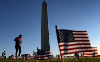 WASHINGTON, DC - SEPTEMBER 20: Volunteers with the COVID Memorial Project install 20,000 American flags on the National Mall as the United States crosses the 200,000 lives lost in the COVID-19 pandemic September 20, 2020 in Washington, DC. The flags are displayed on the grounds of the Washington Monument facing the White House. (Photo by Win McNamee/Getty Images)