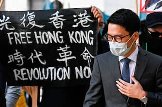 Hong Kong democracy activist Nathan Law stands next to a banner reading "Free Hong Kong. Revolution now" as he attends a demonstration on September 1, 2020 outside the Foreign Office in Berlin, where the Chinese Foreign Minister was expected to hold talks with his German counterpart. (Photo by Tobias SCHWARZ / AFP) (Photo by TOBIAS SCHWARZ/AFP via Getty Images)