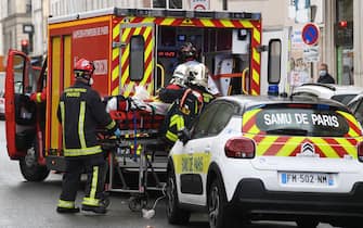 French firefighters load an injured person into a waiting ambulance near the former offices of the French satirical magazine Charlie Hebdo following an alleged attack by a man wielding a knife in the capital Paris on September 25, 2020. - The threats coincide with the trial of 14 suspected accomplices of the perpetrators of the massacres at Charlie Hebdo and a Jewish supermarket that left a total of 17 dead. (Photo by Alain JOCARD / AFP) (Photo by ALAIN JOCARD/AFP via Getty Images)