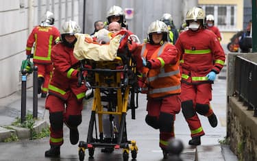 French firefighters push a gurney carrying an injured person near the former offices of the French satirical magazine Charlie Hebdo following an alleged attack by a man wielding a machete in Paris on September 25, 2020. - The threats coincide with the trial of 14 suspected accomplices of the perpetrators of the massacres at Charlie Hebdo and a Jewish supermarket that left a total of 17 dead. (Photo by Alain JOCARD / AFP) (Photo by ALAIN JOCARD/AFP via Getty Images)