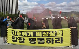 South Korean environmental activists wearing black cloth perform to represent the burning earth during a protest marking a global climate action day in Seoul on September 25, 2020. (Photo by Jung Yeon-je / AFP) (Photo by JUNG YEON-JE/AFP via Getty Images)