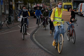 1276622124 LEIDEN, NETHERLANDS. SEPTEMBER 25: Several demonstrators carry banners against climate change on their bikes during the global day of climate action on September 25, 2020 in Leiden, Netherlands. Members of the organization Fridays for Future have marched with their bikes in several Dutch cities, as a protest against the lack of policies to mitigate climate change, during the global day of climate action