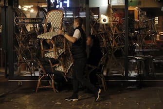 A restaurant employee removes chairs on a terrace in Paris, on September 28, 2020, as the city is again being forced to close bars and restaurants earlier due to the health situation caused by the spread of the Covid-19 caused by the novel coronavirus. - French government imposed fresh curbs to limit the spread of the virus, including on restaurants, bars and sports facilities. (Photo by GEOFFROY VAN DER HASSELT / AFP) (Photo by GEOFFROY VAN DER HASSELT/AFP via Getty Images)