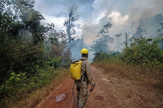 A Forest Guardians member watches an oncoming fire as he fights fires in a burning area of the forest in Alto Rio Guama, east of Belem, Para, Brazil on September 17, 2020. - An Indigenous group called the Forest Guardians are fighting forest fires encroaching on their land with basic equipment. (Photo by JOAO PAULO GUIMARAES / AFP) (Photo by JOAO PAULO GUIMARAES/AFP via Getty Images)