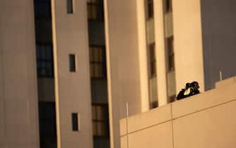 A counter sniper watches while waiting for US President Donald Trump to arrive at Walter Reed National Military Medical Center on October 2, 2020, in Bethesda, Maryland. - President Donald Trump will spend the coming days in a military hospital just outside Washington to undergo treatment for the coronavirus, but will continue to work, the White House said October 2nd. (Photo by Brendan Smialowski / AFP) (Photo by BRENDAN SMIALOWSKI/AFP via Getty Images)
