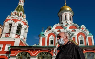 A man wearing a face mask to protect against the coronavirus disease walks past a Russian Orthodox cathedral on Red Square in central Moscow on October 2, 2020. (Photo by Yuri KADOBNOV / AFP) (Photo by YURI KADOBNOV/AFP via Getty Images)