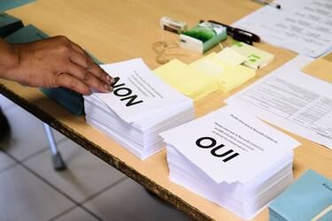A person picks up a voting form as he prepares to cast his vote at a polling station in the referendum on independence on the French South Pacific territory of New Caledonia in Noumea on October 4, 2020. - The French South Pacific territory of New Caledonia votes in an independence referendum on October 4, 2020, which is expected to reject breaking away from France after almost 170 years despite rising support for the move. (Photo by Theo Rouby / AFP) (Photo by THEO ROUBY/AFP via Getty Images)