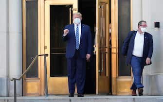 epa08723006 US President Donald J. Trump, wearing a mask, emerges from the front door of Walter Reed National Military Medical Center, in Bethesda, Maryland, USA, 05 October 2020, to board Marine One for a return trip to the White House after receiving treatment for a COVID-19 infection.  EPA/Chris Kleponis / POOL