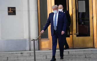 epa08723005 US President Donald J. Trump, wearing a mask, emerges from the front door of Walter Reed National Military Medical Center, in Bethesda, Maryland, USA, 05 October 2020, to board Marine One for a return trip to the White House after receiving treatment for a COVID-19 infection.  EPA/Chris Kleponis / POOL