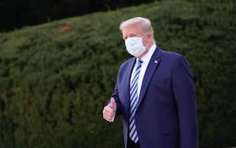 epa08723037 US President Donald J. Trump, wearing a mask, gestures after leaving Walter Reed National Military Medical Center, in Bethesda, Maryland, USA, 05 October 2020, to board Marine One for a return trip to the White House after receiving treatment for a COVID-19 infection.  EPA/Chris Kleponis / POOL