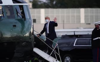 epa08723052 US President Donald J. Trump, wearing a mask, embarks onto Marine One after leaving Walter Reed National Military Medical Center, in Bethesda, Maryland, USA, 05 October 2020, to board Marine One for a return trip to the White House after receiving treatment for a COVID-19 infection.  EPA/Chris Kleponis / POOL