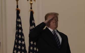 epa08723073 US President Donald J. Trump salutes after returning to the White House, in Washington, DC, USA, 05 October 2020, following several days at Walter Reed National Military Medical Center for treatment for COVID-19.  EPA/KEN CEDENO / POOL