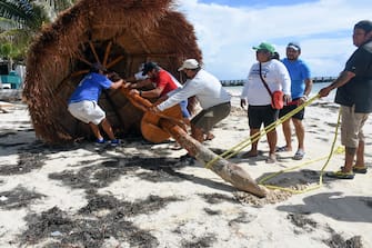 Workers remove a sunshide in preparation for the arrival of Hurrican Delta, in Puerto Morelos, Quintana Roo state, Mexico on October 6, 2020. - Hurricane Delta intensified into a Category 3 storm on Tuesday and is set to slam into Mexico's Yucatan Peninsula early on Wednesday, the US National Hurricane Center said. (Photo by ELIZABETH RUIZ / AFP) (Photo by ELIZABETH RUIZ/AFP via Getty Images)