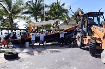 1228925371 Workers and fishermen from the coastal area of Puerto Morelos save their boats in preparation for the arrival of Hurrican Delta, in the state of Quintana Roo, Mexico on October 6, 2020. - Hurricane Delta intensified into a Category 3 storm on Tuesday and is set to slam into Mexico's Yucatan Peninsula early on Wednesday, the US National Hurricane Center said. (Photo by ELIZABETH RUIZ / AFP) (Photo by ELIZABETH RUIZ/AFP via Getty Images)