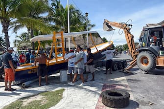 1228925619 Workers and fishermen from the coastal area of Puerto Morelos save their boats in preparation for the arrival of Hurrican Delta, in the state of Quintana Roo, Mexico on October 6, 2020. - Hurricane Delta intensified into a Category 3 storm on Tuesday and is set to slam into Mexico's Yucatan Peninsula early on Wednesday, the US National Hurricane Center said. (Photo by ELIZABETH RUIZ / AFP) (Photo by ELIZABETH RUIZ/AFP via Getty Images)