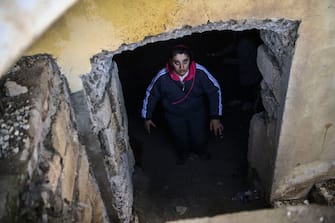 A woman looks on as she stands at the entrance of a basement shelter in the historic city of Shusha on October 8, 2020, some 15 kilometers from the disputed Nagorno-Karabakh province's capital Stepanakert, that was hit by shelling as fighting between Armenian and Azerbaijani forces spilled over today ahead of a first meeting of international mediators in Geneva. - Nagorno-Karabakh broke away from Azerbaijan in a 1990s war that claimed the lives of some 30,000 people. The Armenian separatists declared independence, but no countries recognise its autonomy and it is still acknowledged by world leaders as part of Azerbaijan. (Photo by ARIS MESSINIS / AFP) (Photo by ARIS MESSINIS/AFP via Getty Images)