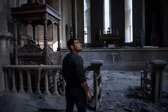 TOPSHOT - A man looks on as he stands in the rubble and debris on October 8, 2020 inside the damaged Ghazanchetsots (Holy Saviour) Cathedral in the historic city of Shusha, some 15 kilometers from the disputed Nagorno-Karabakh province's capital Stepanakert, that was hit by a bomb as fighting between Armenian and Azerbaijani forces spilled over today ahead of a first meeting of international mediators in Geneva. - Nagorno-Karabakh broke away from Azerbaijan in a 1990s war that claimed the lives of some 30,000 people. The Armenian separatists declared independence, but no countries recognise its autonomy and it is still acknowledged by world leaders as part of Azerbaijan. (Photo by ARIS MESSINIS / AFP) (Photo by ARIS MESSINIS/AFP via Getty Images)