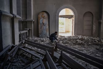 A man stands in the rubble and debris on October 8, 2020 inside the damaged Ghazanchetsots (Holy Saviour) Cathedral in the historic city of Shusha, some 15 kilometers from the disputed Nagorno-Karabakh province's capital Stepanakert, that was hit by a bomb as fighting between Armenian and Azerbaijani forces spilled over today ahead of a first meeting of international mediators in Geneva. - Nagorno-Karabakh broke away from Azerbaijan in a 1990s war that claimed the lives of some 30,000 people. The Armenian separatists declared independence, but no countries recognise its autonomy and it is still acknowledged by world leaders as part of Azerbaijan. (Photo by ARIS MESSINIS / AFP) (Photo by ARIS MESSINIS/AFP via Getty Images)
