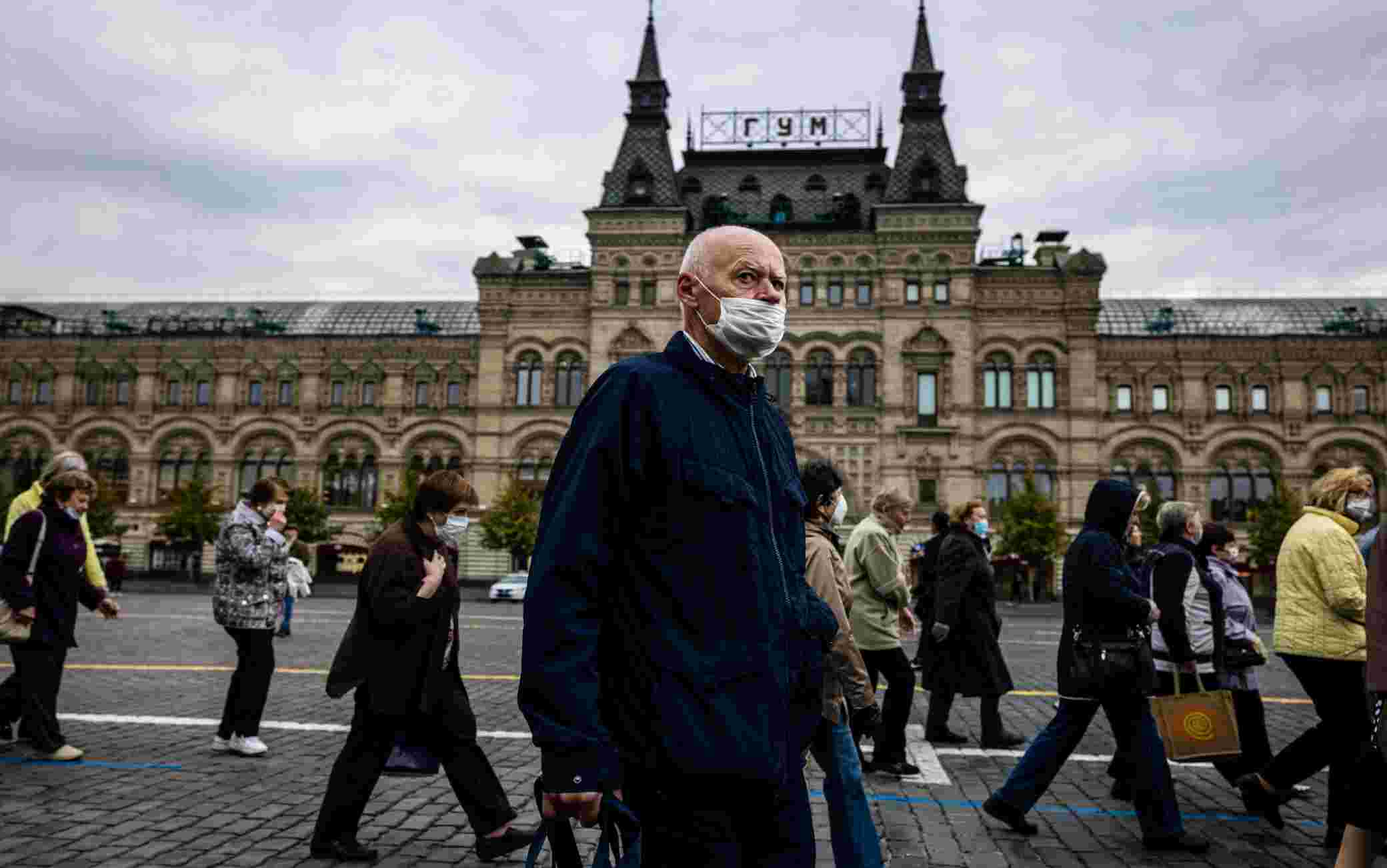 A man wearing a face mask to protect against the coronavirus disease walks on Red Square in front of the GUM department store in central Moscow on October 7, 2020. (Photo by Dimitar DILKOFF / AFP) (Photo by DIMITAR DILKOFF/AFP via Getty Images)