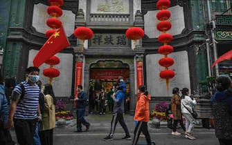 BEIJING, CHINA - OCTOBER 08: Chinese tourists walk in a shopping area on October 8, 2020 during the final day of the 'Golden Week' holiday in Beijing, China. Officials are expecting the Golden Week holiday to boost Chinas consumer economy as people were encouraged to use the 8-day break to travel and spend. Tourist sites including the Great Wall were packed, with tickets selling out most days given epidemic restrictions and capacity capped at 75%. An estimated 550 million people are said to be on the move, with crowded train stations and attractions providing a sharply different view of a country that was largely shut down by the coronavirus outbreak earlier this year.  Officially, case numbers have remained low, though authorities are concerned about another wave of infection with flu season ahead. (Photo by Kevin Frayer/Getty Images)