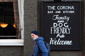 A man walks past The Corona pub on the Southside of Glasgow on October 8, 2020, on the eve of a two-week closure of pubs due to an increase in the number of cases of the novel coronavirus COVID-19. - Scotland, on October 7, 2020, ordered a two-week closure of pubs in the central part of the country including the main cities Glasgow and Edinburgh.  First Minister Nicola Sturgeon said the measures, to last for 16 days from October 9, were designed as "short, sharp action to arrest the worrying increase in infection". (Photo by Andy Buchanan / AFP) (Photo by ANDY BUCHANAN/AFP via Getty Images)