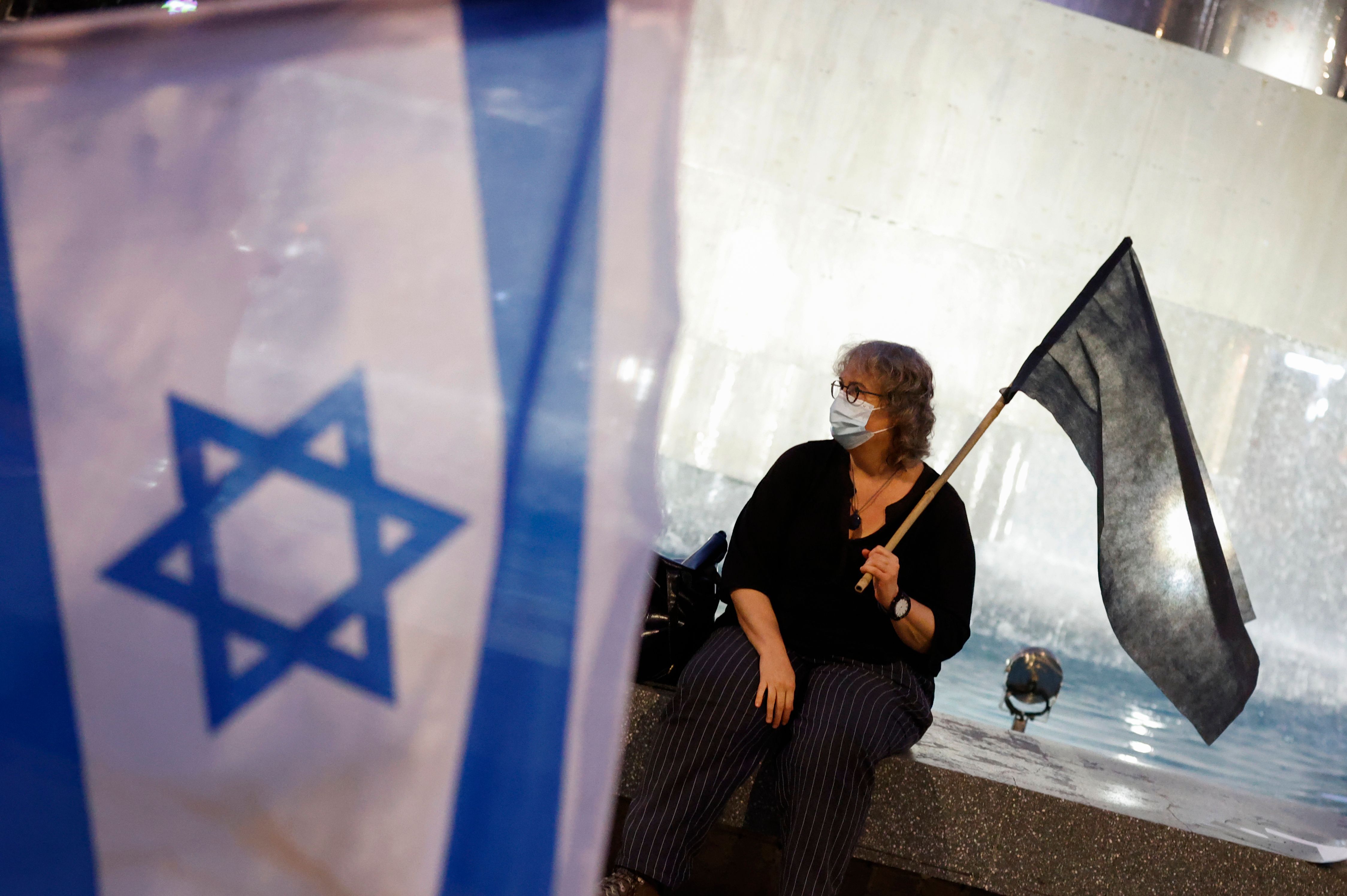 Israeli protesters, wearing protective masks due to the COVID-19 pandemic, participate in a rally against Prime Minister Benjamin Netanyahu and his handling of the coronavirus pandemic in the Israeli coastal city of Tel Aviv on October 8, 2020 (Photo by JACK GUEZ).  / AFP) (Photo by JACK GUEZ / AFP via Getty Images)