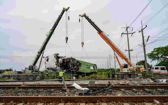 The wreckage of an overturned bus involved in a deadly collision with a train is lifted off the tracks next to Khlong Kwaeng Klan railway station in Chachoengsao province, east of the Thai capital Bangkok, on October 11, 2020. (Photo by Mladen ANTONOV / AFP) (Photo by MLADEN ANTONOV/AFP via Getty Images)