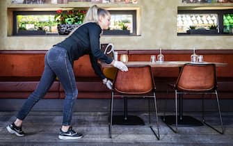 Una cameriera sposta il tavolo di un ristorante 