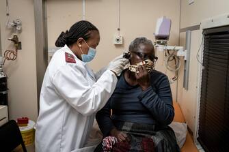 SOUTH AFRICA PANDEMIC CORONAVIRUS TRAVEL BAN epa08659056 A nurse examines a patient at the Phelophepa Health train in Springs, Johannesburg, 10 August 2020. The train consists of 5 clinics, and was initially deployed during the HIV/AIDS pandemic. Now it renders its usual health services as well as providing COVID-19 testing. South Africa is presently in level 2 lockdown but with infection rates dropping level 1 may be brought into effect shortly. EPA/YESHIEL PANCHIA