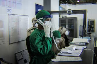 1227896398 A medical staff in Personal Protective Equipment (PPE) calls for other medical team at the makeshift hospital where patients infected by the COVID-19 (novel coronavirus) are treated inside Millenium Hall, one of the country's largest event center, in Addis Ababa, on August 3, 2020. (Photo by AMANUEL SILESHI / AFP) (Photo by AMANUEL SILESHI/AFP via Getty Images)