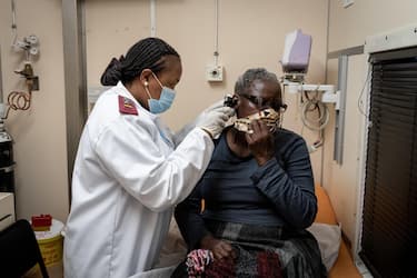 epa08659056 A nurse examines a patient at the Phelophepa Health train in Springs, Johannesburg, 10 August 2020. The train consists of 5 clinics, and was initially deployed during the HIV/AIDS pandemic. Now it renders its usual health services as well as providing COVID-19 testing. South Africa is presently in level 2 lockdown but with infection rates dropping level 1 may be brought into effect shortly. EPA/YESHIEL PANCHIA