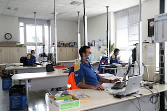Impiegati dello stabilimento New Holland di CNH Industrial Modena al lavoro in ufficio con le scrivanie distanziate per contrastare il Coronavirus