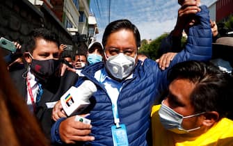 Luis Arce, center, who is running for president with the Movement Towards Socialism (MAS) party, leaves the polling station after voting during general elections in La Paz, Bolivia, Sunday, Oct. 18, 2020. (AP Photo/Juan Karita)
