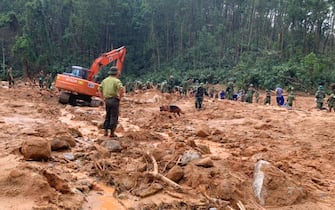 Rescue workers recover bodies of army officers buried in a landslide in Thua Thien-Hue province, Vietnam on Thursday, Oct. 15, 2020. Rescuers has recovered 13 bodies from a landslide due to torrential rains that flooded a vast area in central Vietnam and killed at least 36 people, left a dozen others still missing since last weekend. (Tran Le Lam/VNA via AP)