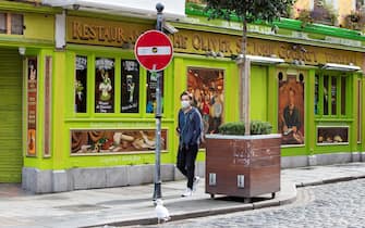 A pedestrian wearing a face mask or covering due to the COVID-19 pandemic, walks past a temporarily closed down pub in Dublin on September 18, 2020, following reports that further lockdown restrictions could be imposed to help mitigate the spread of the novel coronavirus. - Ireland's capital could face further restrictions this weekend after public health experts raised concerns when its 14-day incidence rate jumped to more than 100. (Photo by Paul Faith / AFP) (Photo by PAUL FAITH/AFP via Getty Images)