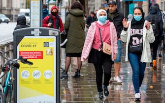 Pedestrians wearing face coverings due to the COIVD-19 pandemic, walk in Dublin on October 19, 2020, amid reports that further lockdown restrictions could be imposed to help mitigate the spread of the novel coronavirus. - Ireland will crank up coronavirus restrictions, prime minister Micheal Martin said last week, announcing a raft of new curbs along the border with the British province of Northern Ireland. (Photo by PAUL FAITH / AFP) (Photo by PAUL FAITH/AFP via Getty Images)