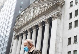 epa08775959 A man walks past the New York Stock Exchange on Wall Street in New York, New York, USA, 26 October 2020. The Dow Jones industrial average was down as much as 900 points today as investors reportedly reacted to an uptick in the number of coronavirus infections.  EPA/JUSTIN LANE