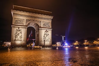epa08779413 A police car drives next to the Arc de Triomphe on a night shift to control the night curfew, in Paris, France, October 27, 2020. President Emmanuel Macron will unveil new measures to stop the Covid-19 epidemic on the eve of October 28. 2020.  EPA/MOHAMMED BADRA