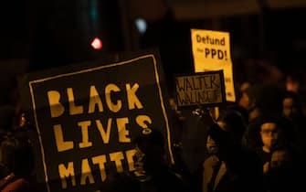 PHILADELPHIA, PA - OCTOBER 27:  Demonstrators hold placards reading "BLACK LIVES MATTER," "Walter Wallace JR." and DEFUND PPD" as they gather in protest near the location where Walter Wallace, Jr. was killed by two police officers on October 27, 2020 in Philadelphia, Pennsylvania. Protests erupted after the fatal shooting of 27-year-old Wallace Jr, who Philadelphia police officers claimed was armed with a knife. (Photo by Mark Makela/Getty Images)