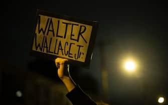 PHILADELPHIA, PA - OCTOBER 27: A demonstrator holds a placard reading "WALTER WALLACE JR." during a protest near the location where Walter Wallace, Jr. was killed by two police officers on October 27, 2020 in Philadelphia, Pennsylvania. Protests erupted after the fatal shooting of 27-year-old Wallace Jr, who Philadelphia police officers claimed was armed with a knife. (Photo by Mark Makela/Getty Images)                                           