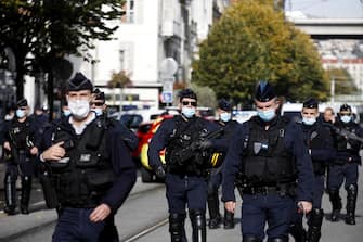 epa08782529 French police officers stand at a security perimeter following a knife attack at the Notre Dame Basilica church in Nice, France, 29 October 2020. According to recent reports, at least three people are reported to have died in what officials treat as a terror attack.  EPA/SEBASTIEN NOGIER