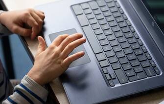 CARDIFF, WALES - JUNE 29: A close-up of a child's hands on a laptop at Roath Park Primary School on June 29, 2020 in Cardiff, Wales. Schoolchildren of all years will be able to return after months of pandemic-inspired closure, but only a third of a school's pupils will be allowed to attend at once. Due to Wales' devolved governance, the decision to reopen schools rested with its education minister, not the British government. (Photo by Matthew Horwood/Getty Images)