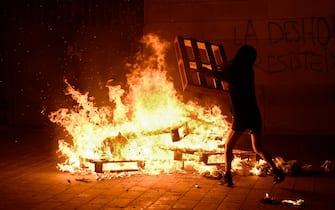 Protesters start a bonfire during a demonstration against evictions amid the COVID-19 pandemic in Barcelona on October 31, 2020. - Protesters clashed with police in central Barcelona yesterday after hundreds gathered to demonstrate against new coronavirus restrictions, including a curfew and a ban on leaving the city over the holiday weekend. (Photo by Josep LAGO / AFP) (Photo by JOSEP LAGO/AFP via Getty Images)