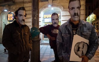 Three people cover their faces with a mask depicting Spanish Prime Minister Pedro Sanchez with a Hitlerian moustache during a demonstration against the restrictions imposed to curb rising infections of the novel coronavirus in Granada on October 31, 2020. (Photo by JORGE GUERRERO / AFP) (Photo by JORGE GUERRERO/AFP via Getty Images)