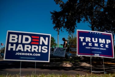 Biden and Trump campaign signs are displayed as voters line-up to cast their ballots during early voting at the Alafaya Branch Library in Orlando, Florida, on October 30, 2020. - Trump and Biden are focusing their greatest efforts on traditional battlegrounds that will decide the election -- such as Florida, where both campaigned this week. (Photo by Ricardo ARDUENGO / AFP) (Photo by RICARDO ARDUENGO/AFP via Getty Images)